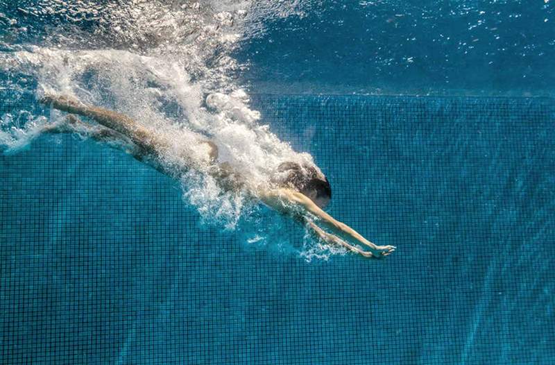 7 beneficii ale înotului care te vor face să vrei să te strecori pe un membru al piscinei interioare