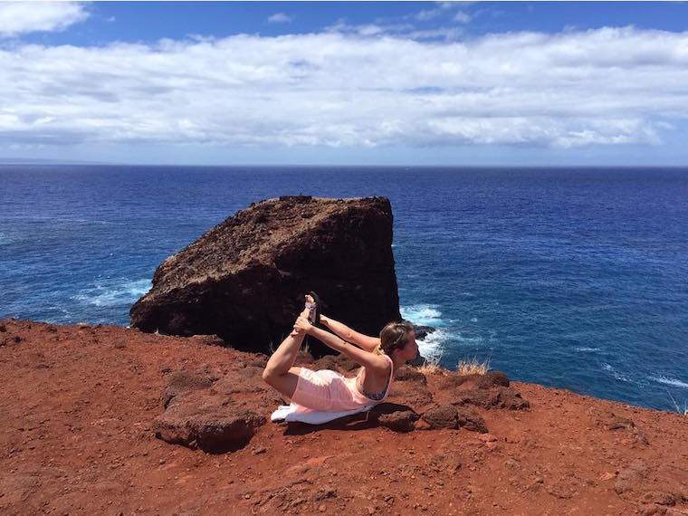 Perhatian orang melakukan yoga di cliffside sekarang